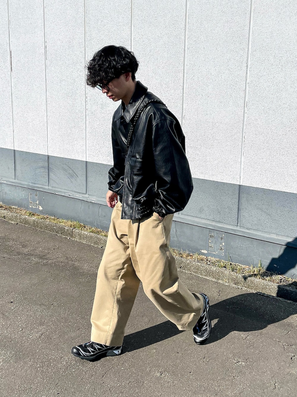 ブラック系のブルゾン、ブラック系のショルダーバッグ、ベージュ系のスウェットを着用したメンズの秋コーディネートの2枚目の写真