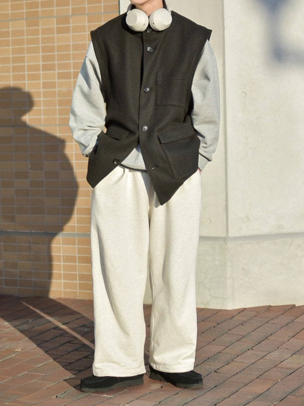 グレー系のスウェット、ホワイト系のスウェットパンツ、ブラック系のモカシン/デッキシューズを着用したメンズの冬コーディネートの4枚目の写真