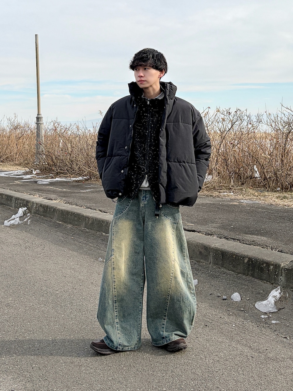 ブラック系のニット/セーター、グレー系のスウェット、ブラック系のダウンジャケット/コートを着用したメンズの冬コーディネートの2枚目の写真