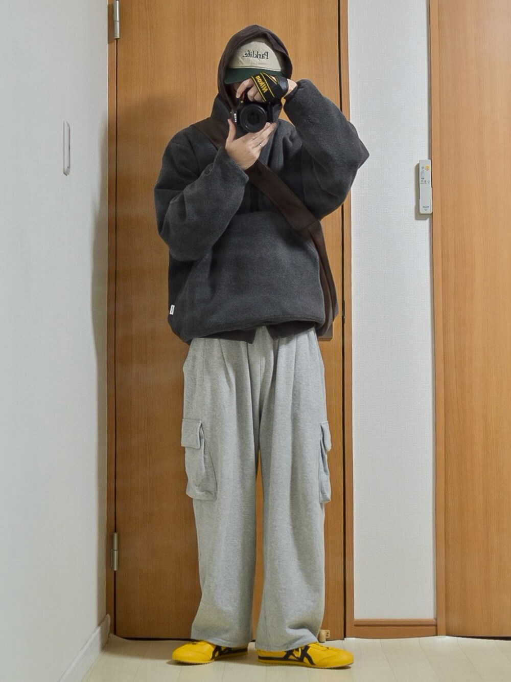 ブラック系のブルゾン、ブラウン系のパーカー、グレー系のスウェットパンツを着用したメンズの冬コーディネートの2枚目の写真