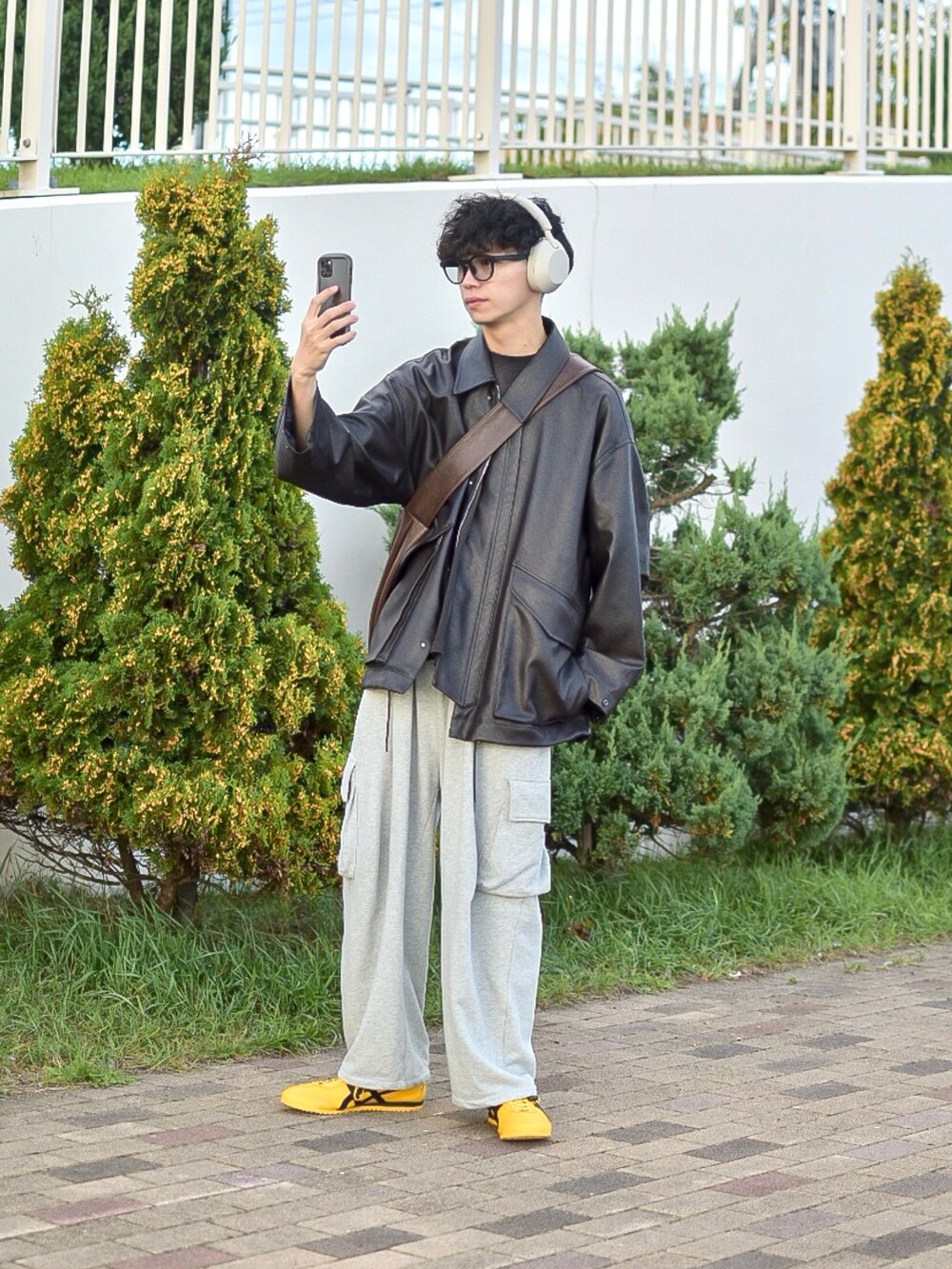 ブラウン系のブルゾン、ブラック系のTシャツ/カットソー、グレー系のスウェットパンツを着用したメンズの秋コーディネートの2枚目の写真