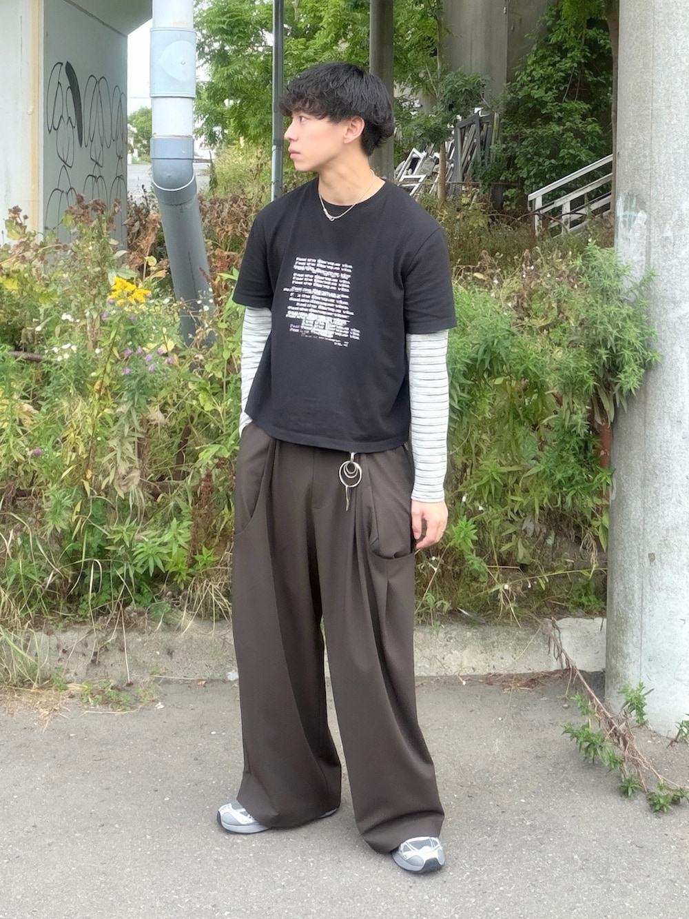 ブラック系のTシャツ/カットソー、グレー系のTシャツ/カットソー、ブラウン系のスラックスを着用したメンズの秋コーディネートの2枚目の写真