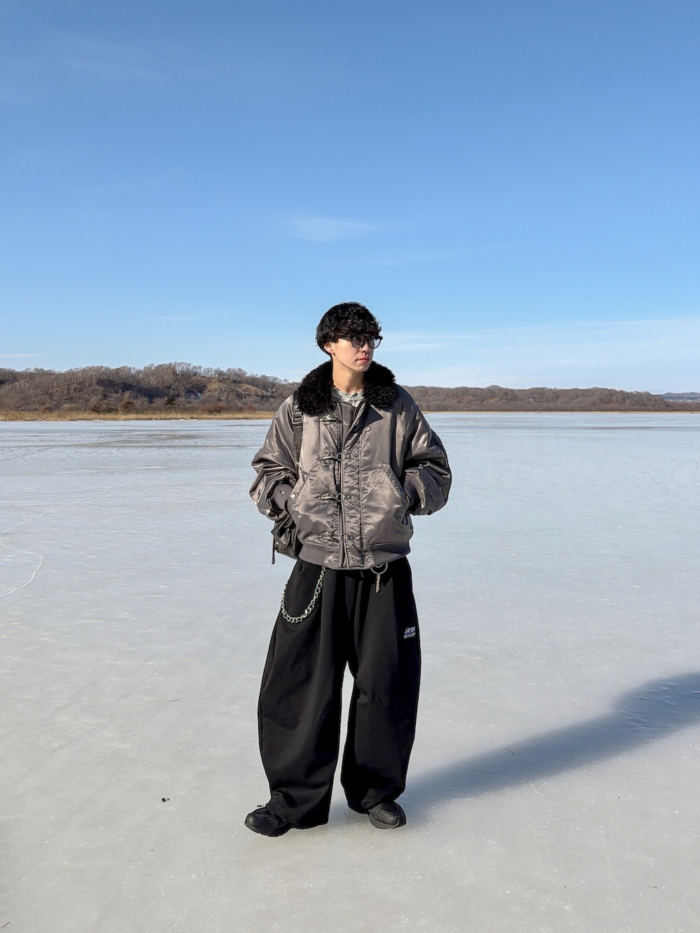 グレー系のスウェット、ブラック系のスウェットパンツ、グレー系のブルゾンを着用したメンズの冬コーディネートの2枚目の写真