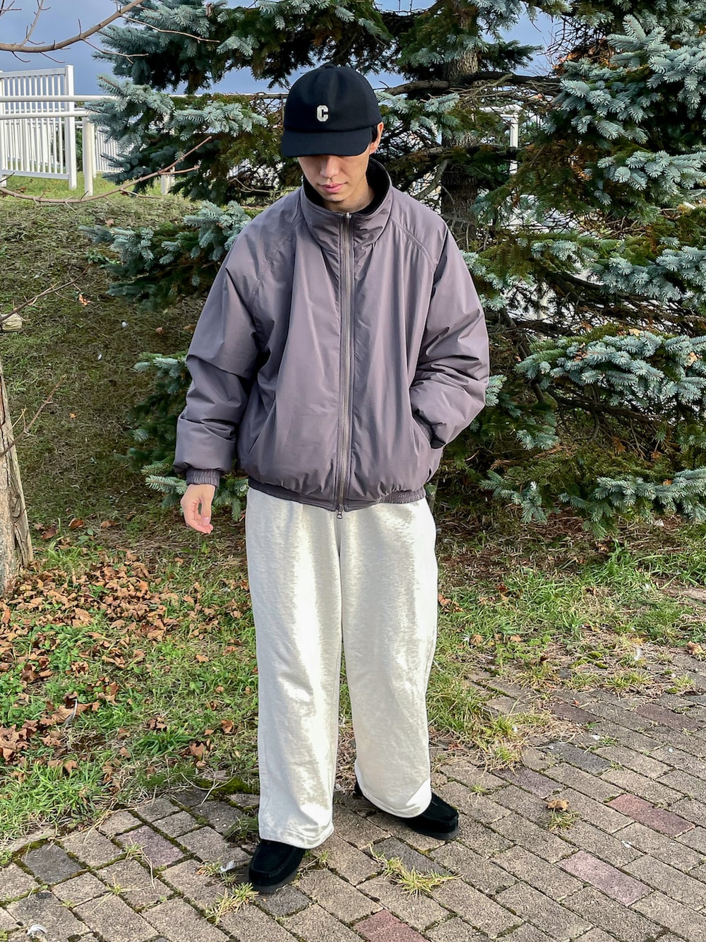 グレー系のジャケット/アウター、ホワイト系のスウェットパンツ、ブラック系のキャップを着用したメンズの秋コーディネートの2枚目の写真
