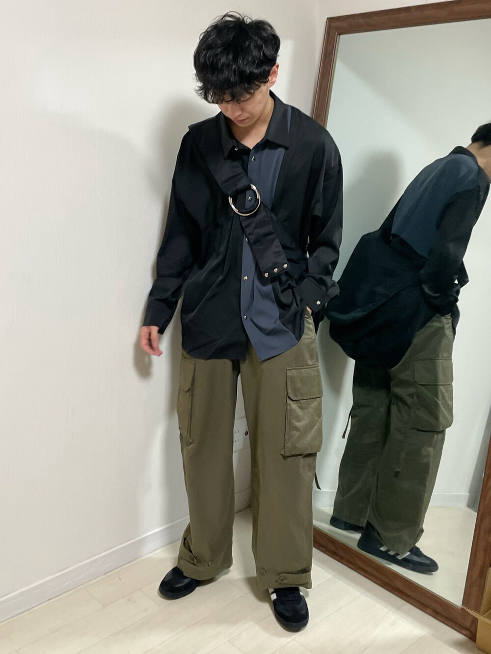 ブラック系のシャツ/ブラウス、グリーン系のカーゴパンツ、ブラック系のスニーカーを着用したメンズの春コーディネートの2枚目の写真