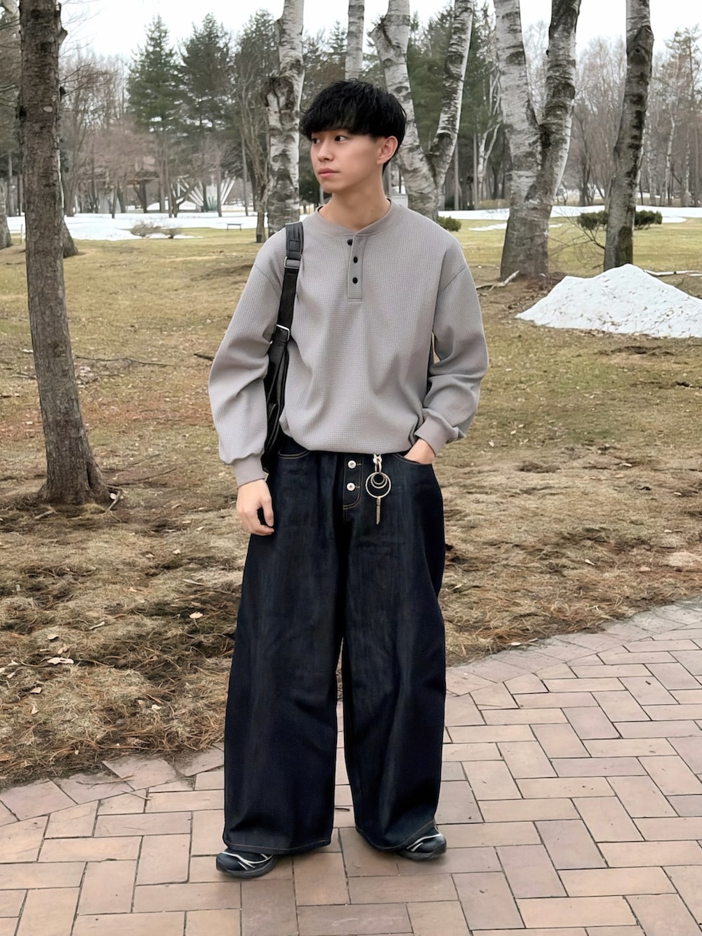 グレー系のTシャツ/カットソー、ブルー系のデニムパンツ、ブラック系のショルダーバッグを着用したメンズの春コーディネートの3枚目の写真