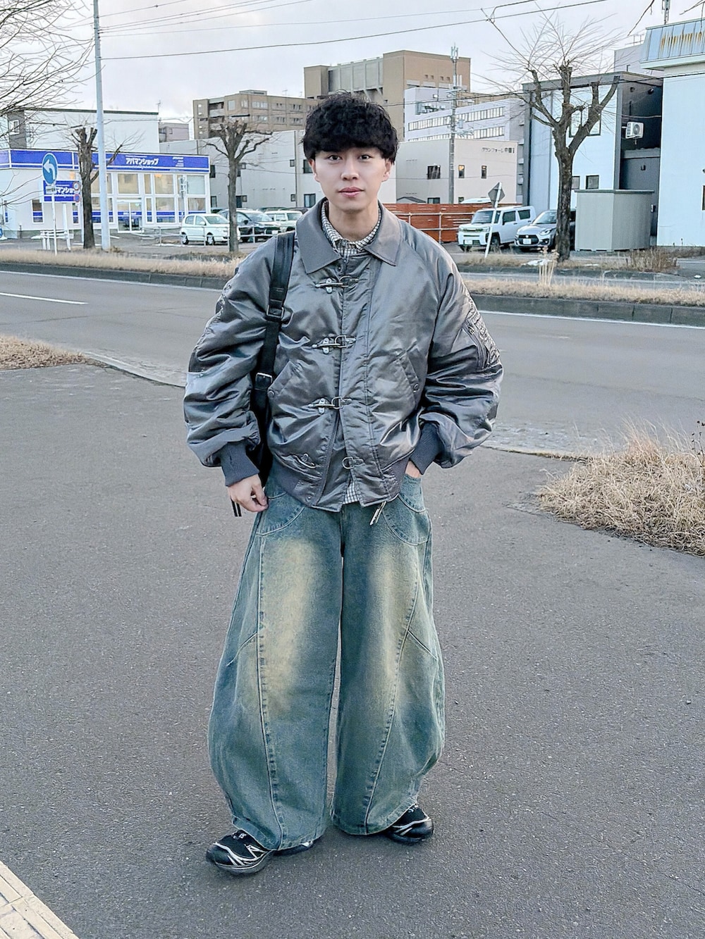 グレー系のブルゾン、ホワイト系のシャツ/ブラウス、ブルー系のデニムパンツを着用したメンズの冬コーディネートの4枚目の写真