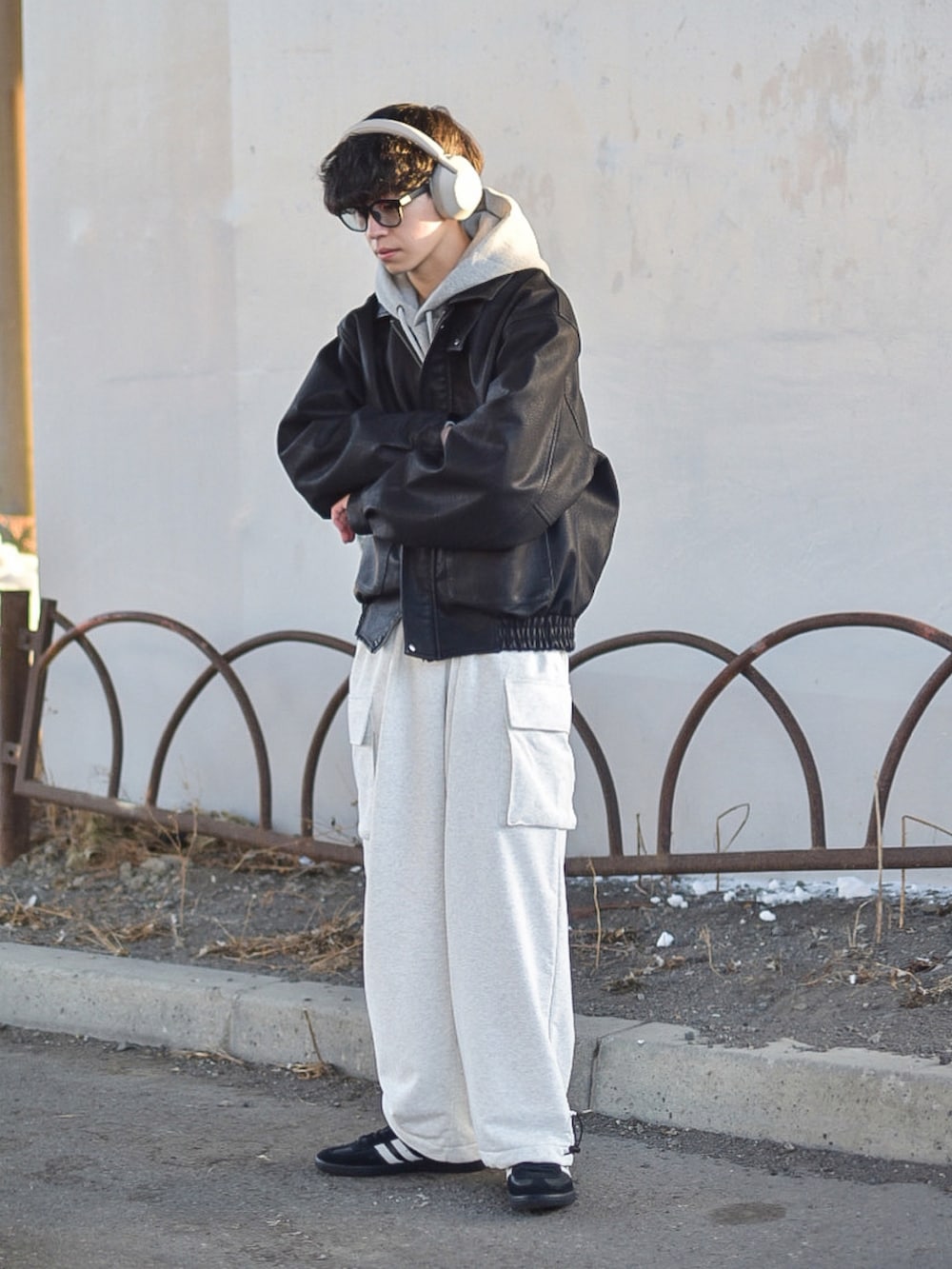 ブラック系のブルゾン、ブラック系のスニーカー、グレー系のパーカーを着用したメンズの冬コーディネートの3枚目の写真
