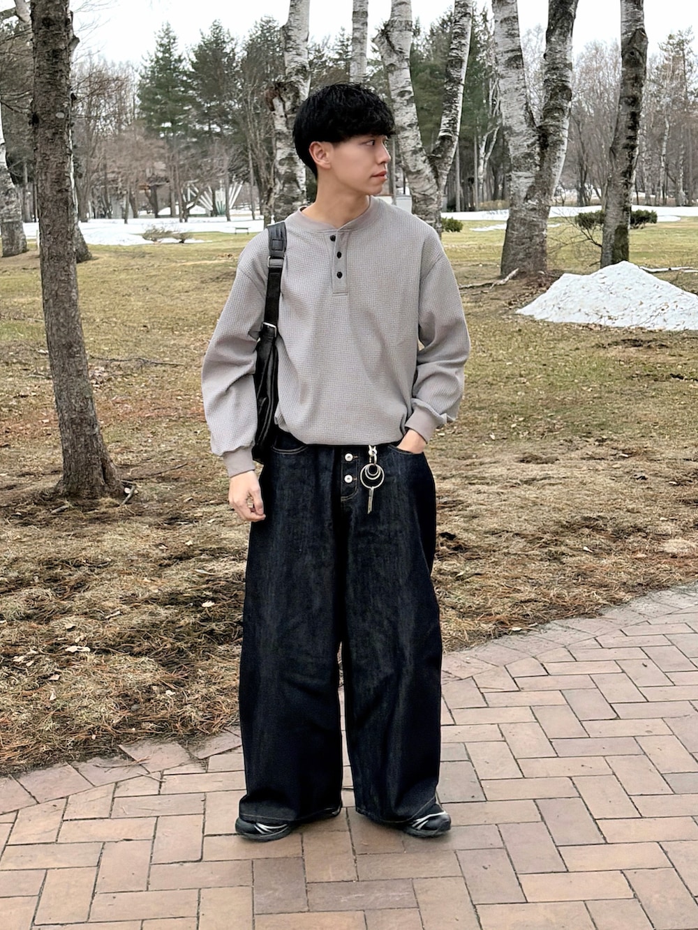 グレー系のTシャツ/カットソー、ブルー系のデニムパンツ、ブラック系のショルダーバッグを着用したメンズの春コーディネートの4枚目の写真