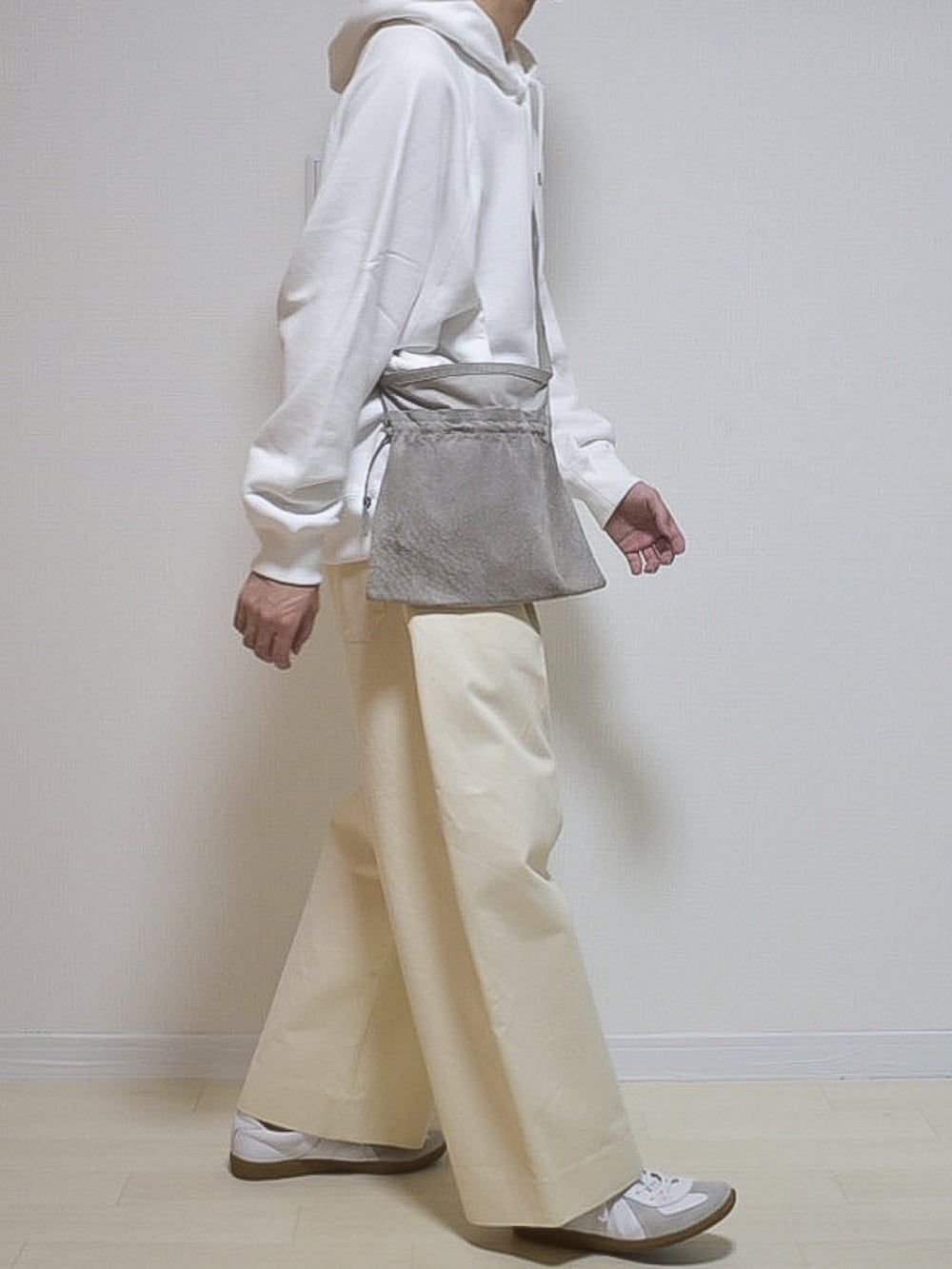 ホワイト系のパーカー、ホワイト系のチノパンツ、ホワイト系のスニーカーを着用したメンズの夏コーディネートの3枚目の写真