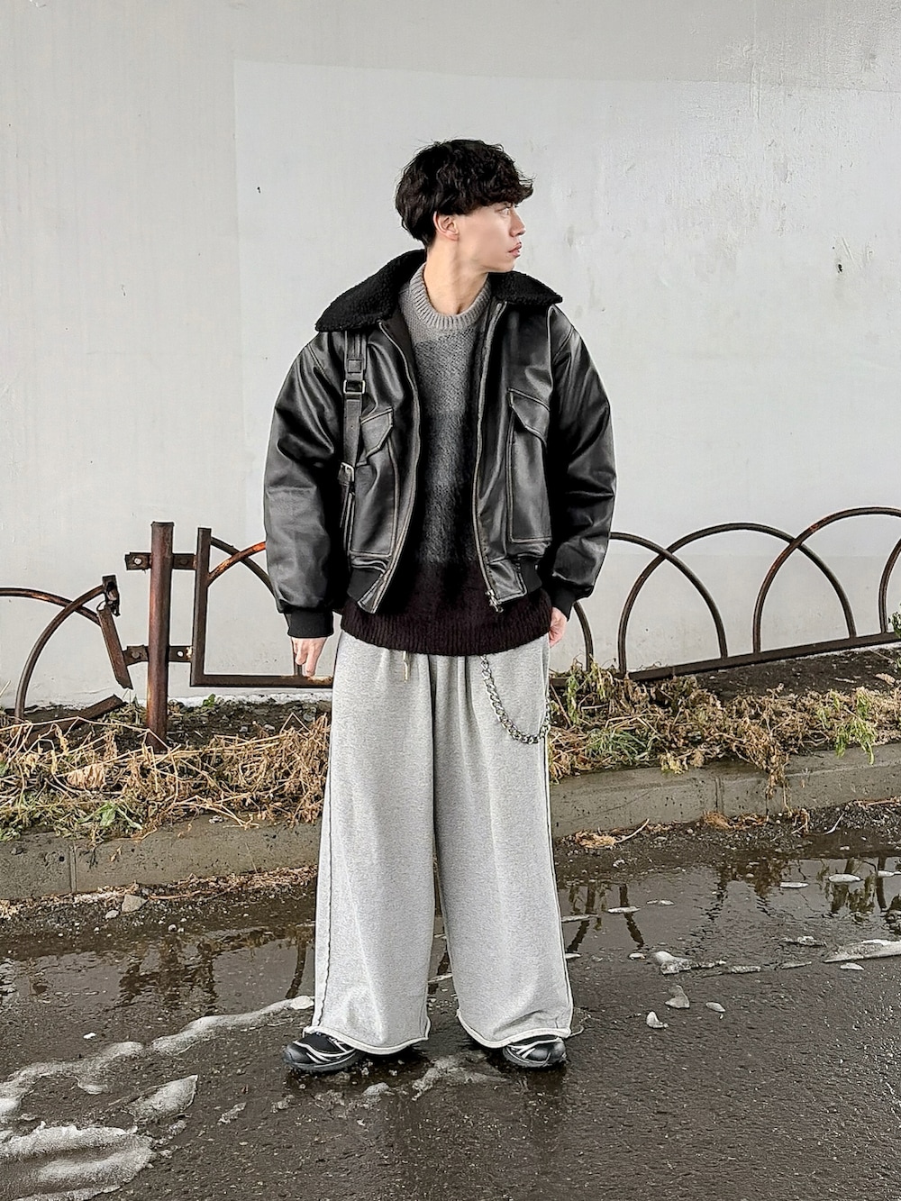 ブラック系のニット/セーター、ブラック系のブルゾン、グレー系のスウェットパンツを着用したメンズの冬コーディネートの3枚目の写真