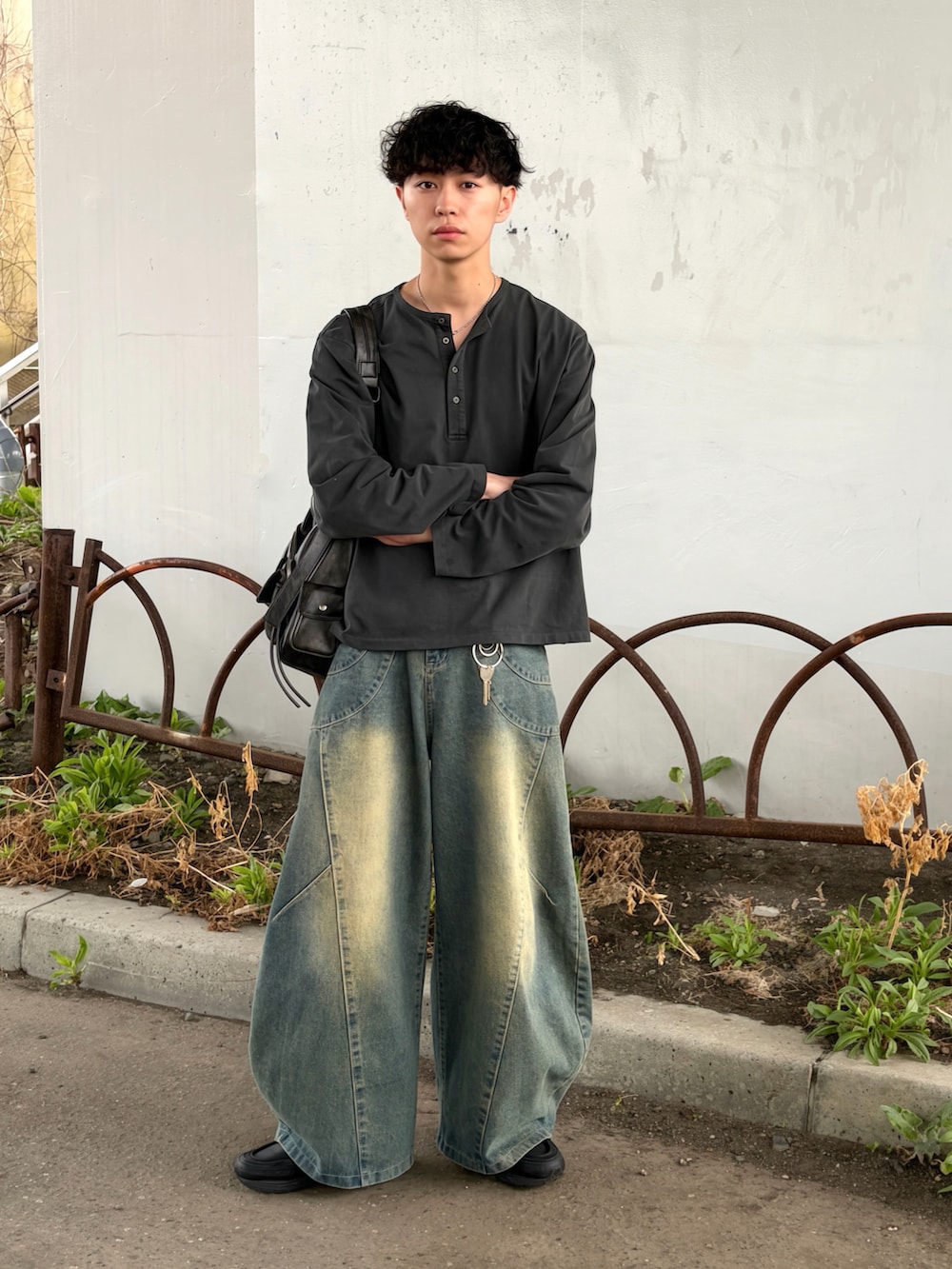 ブルー系のデニムパンツ、グレー系のTシャツ/カットソー、ブラック系のショルダーバッグを着用したメンズの春コーディネートの2枚目の写真