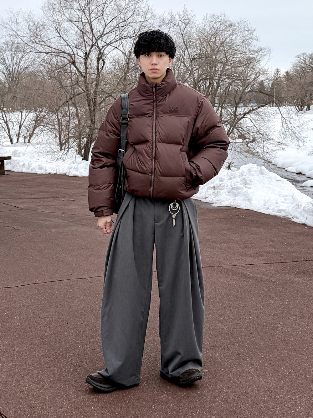 グレー系のスウェット、ブラウン系のダウンジャケット/コート、グレー系のスラックスを着用したメンズの冬コーディネートの2枚目の写真