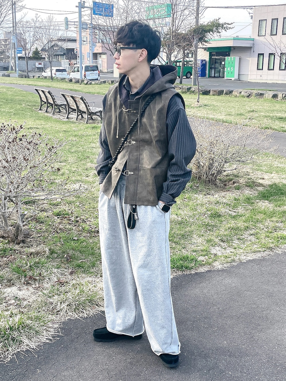 ブラウン系のベスト、グレー系のシャツ/ブラウス、グレー系のスウェットパンツを着用したメンズの春コーディネートの2枚目の写真