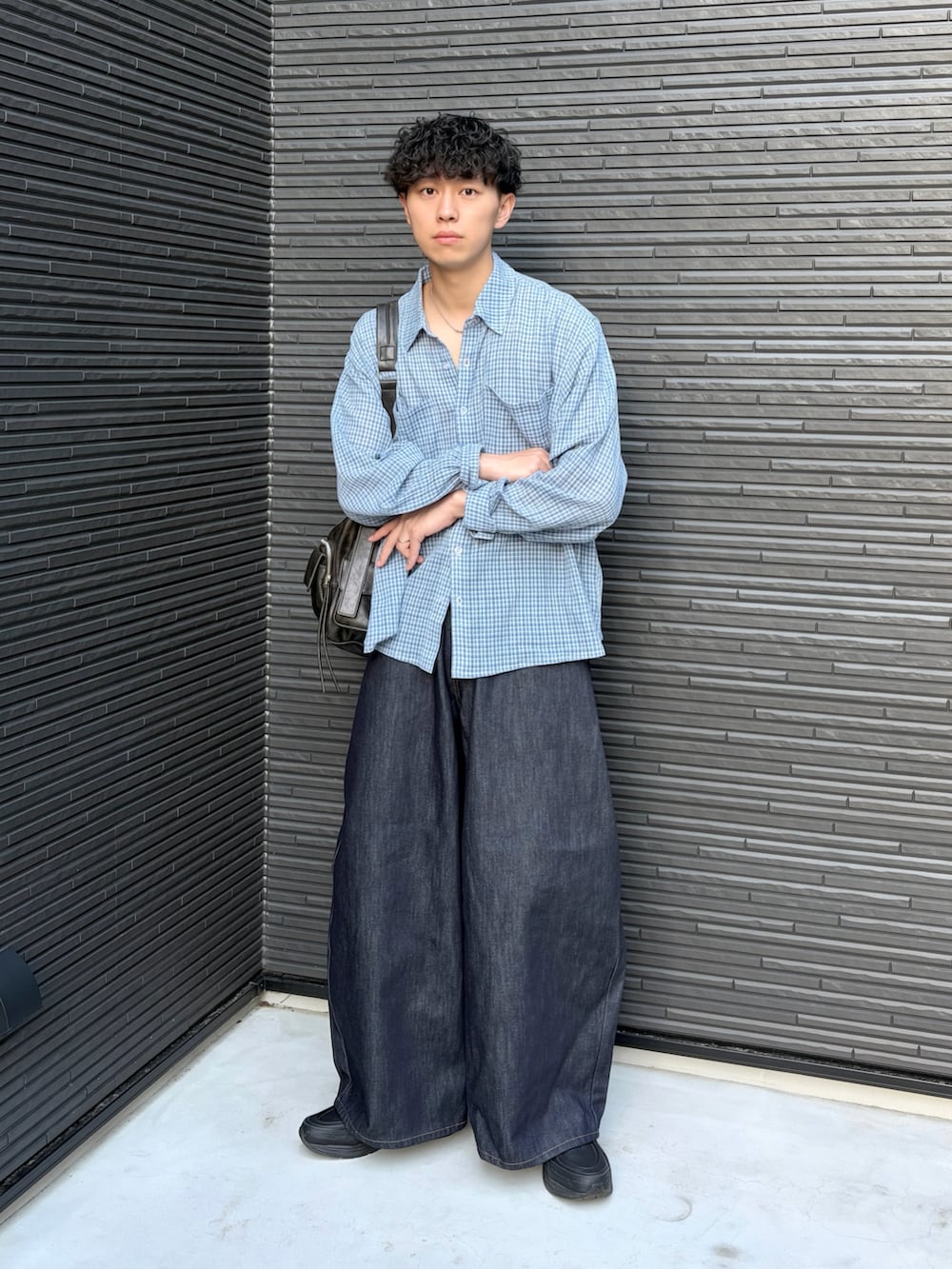 ブルー系のシャツ/ブラウス、ブルー系のデニムパンツ、ブラック系のショルダーバッグを着用したメンズの春コーディネートの2枚目の写真