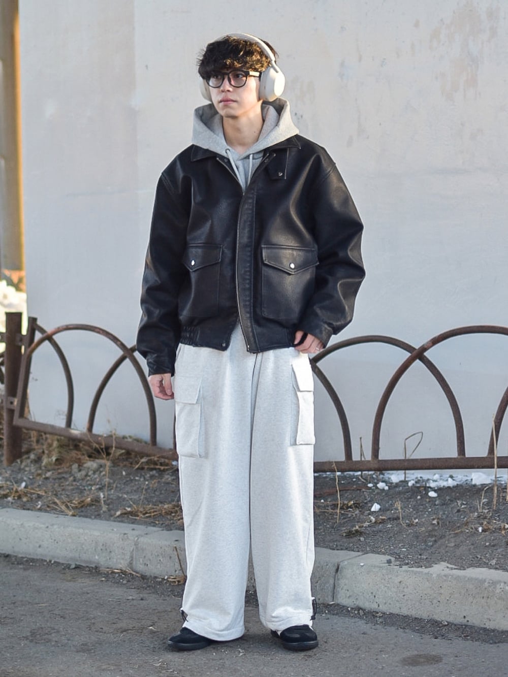 ブラック系のブルゾン、ブラック系のスニーカー、グレー系のパーカーを着用したメンズの冬コーディネートの2枚目の写真