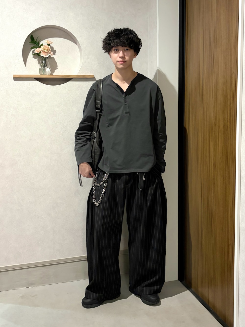 グレー系のTシャツ/カットソー、ブラック系のスラックス、ブラック系のシューズを着用したメンズの春コーディネートの2枚目の写真