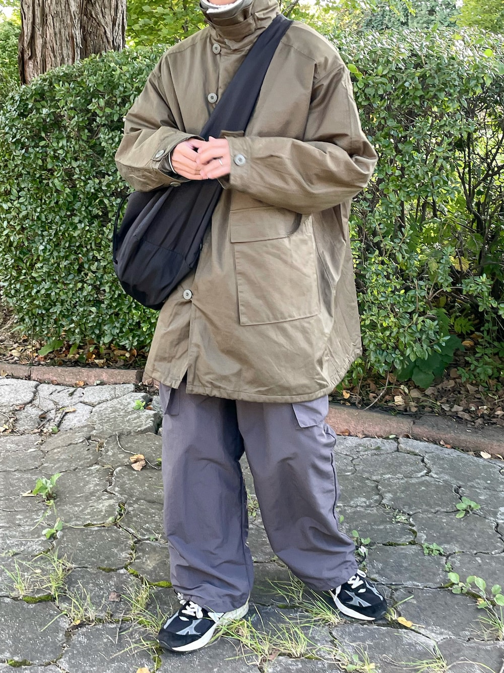 グリーン系のモッズコート、グレー系のカーゴパンツを着用したメンズの秋コーディネートの2枚目の写真