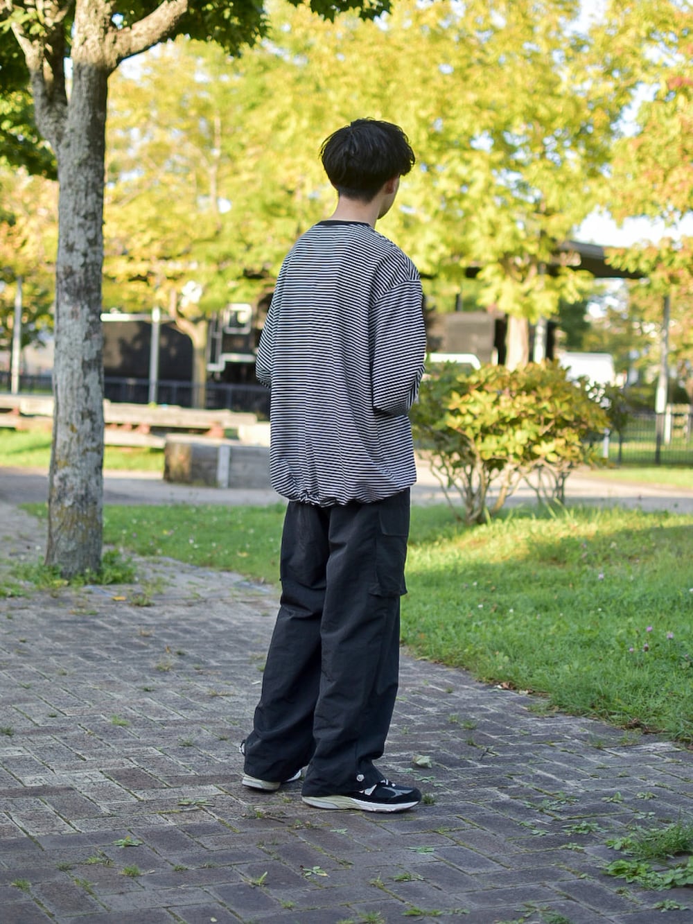 ブラック系のシューズ、ブラック系のカーゴパンツ、ブラック系のTシャツ/カットソーを着用したメンズの秋コーディネートの4枚目の写真