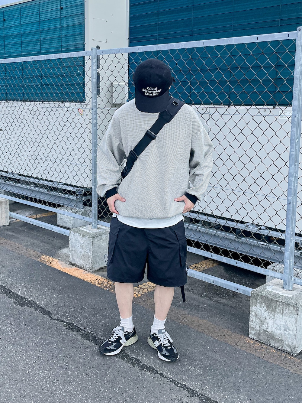 ブラック系のカーゴパンツ、ブラック系のトップス、ブラック系のショルダーバッグを着用したメンズの夏コーディネートの2枚目の写真