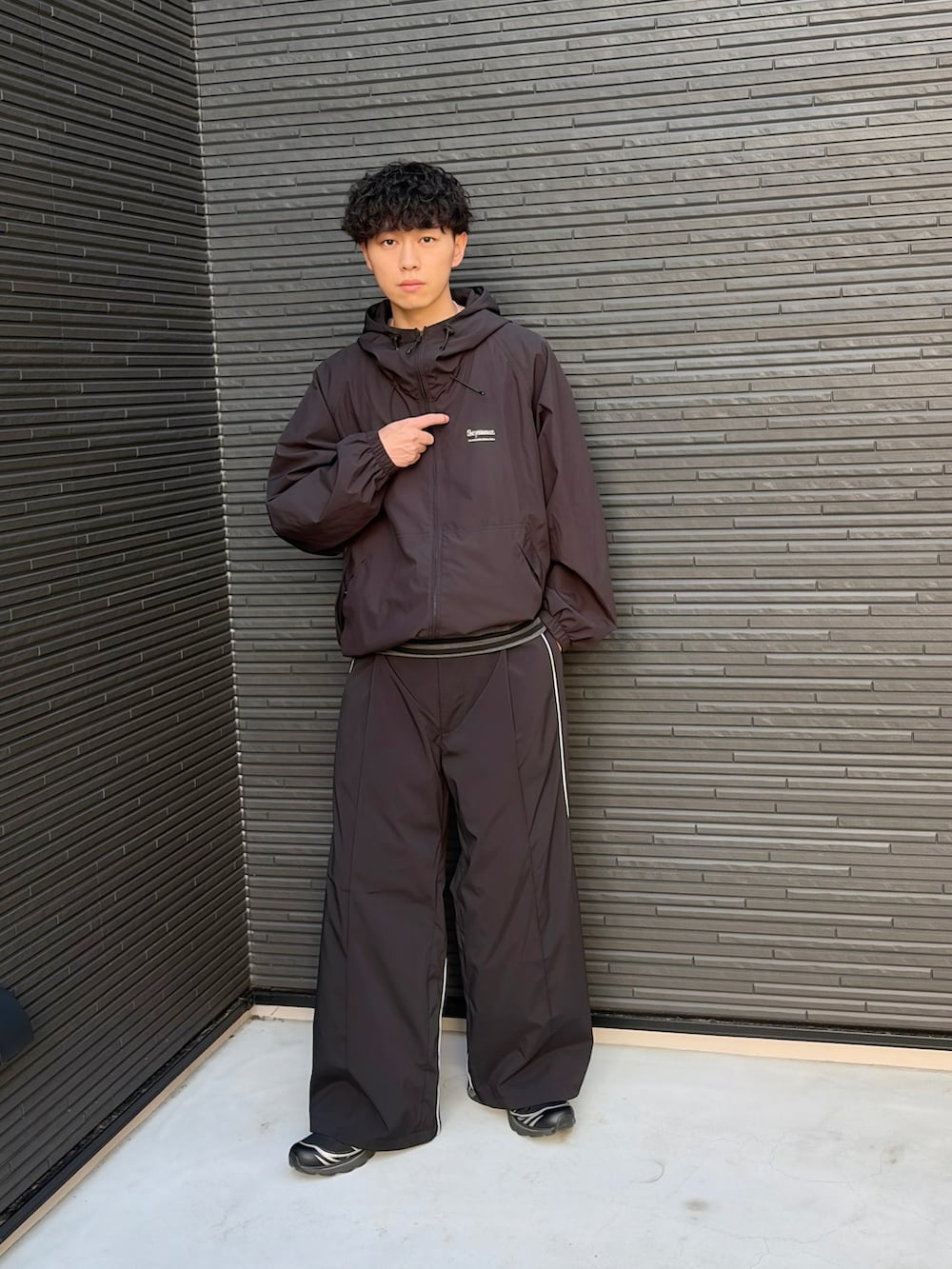ブラック系のスウェットパンツ、ブラック系のTシャツ/カットソー、ブラック系のナイロンジャケットを着用したメンズの春コーディネートの3枚目の写真