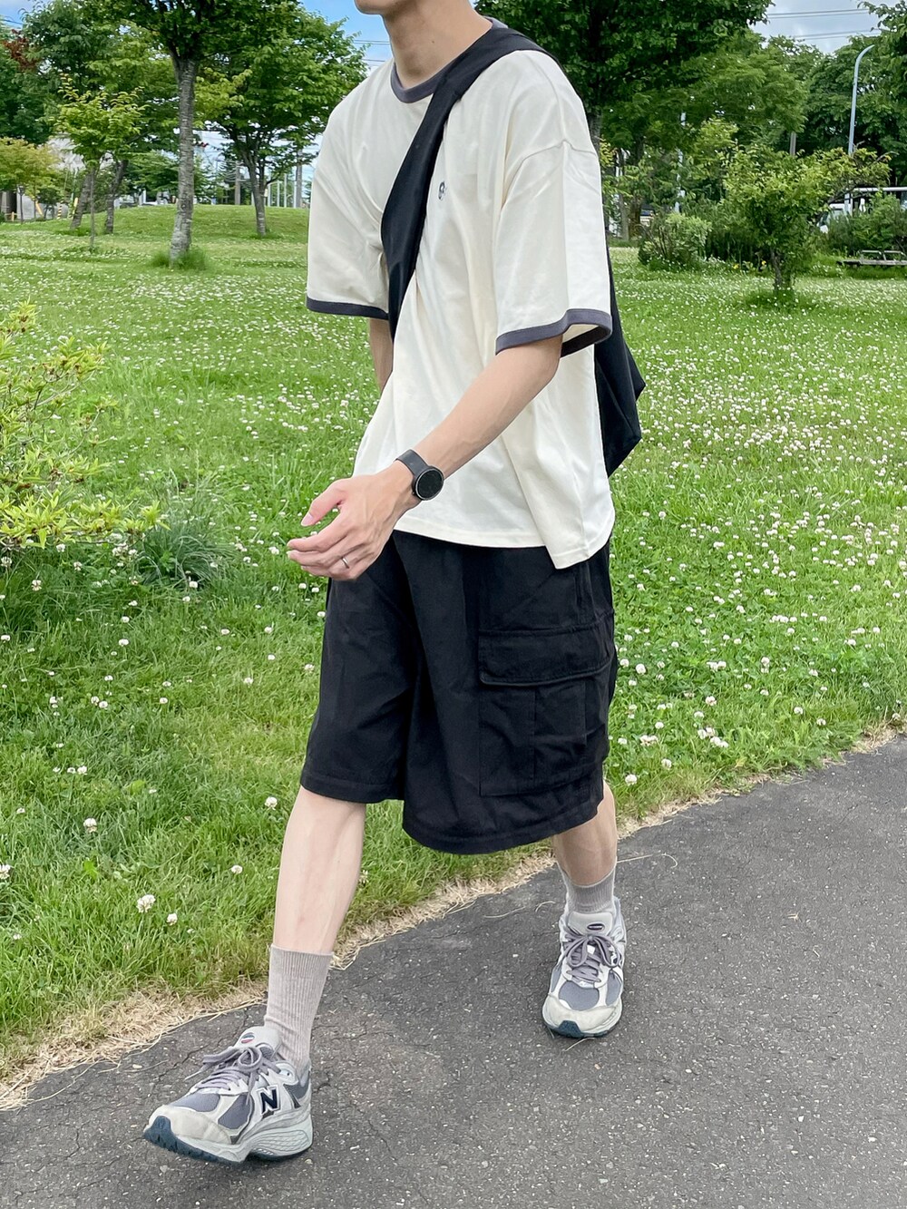 ホワイト系のトップス、ブラック系のパンツ、グレー系のスニーカーを着用したメンズの夏コーディネートの5枚目の写真