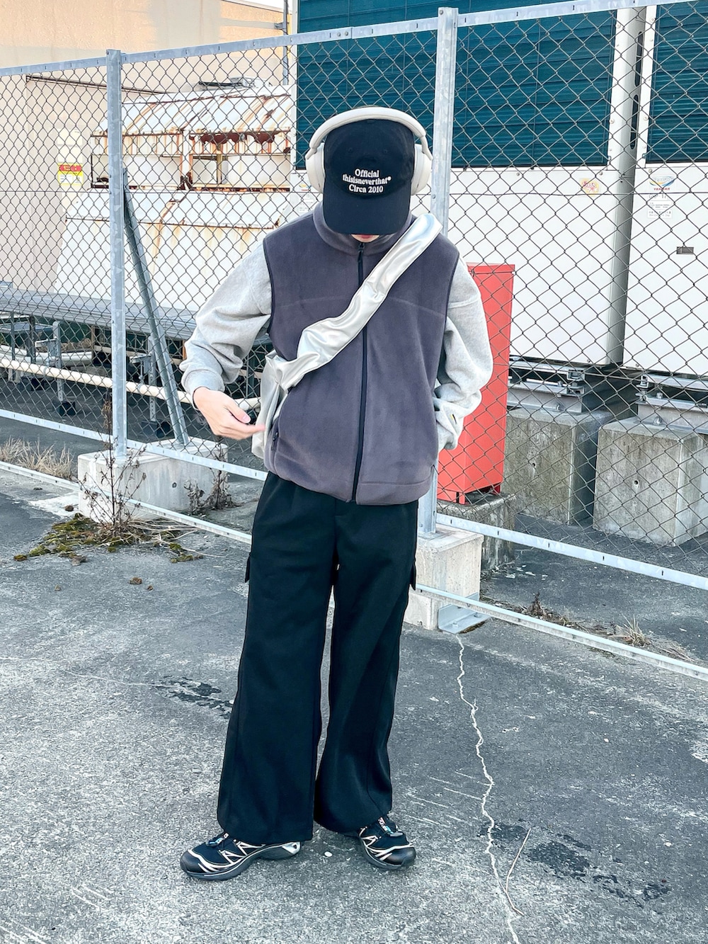 グレー系のベスト、ブラック系のカーゴパンツ、ブラック系のスニーカーを着用したメンズの冬コーディネートの3枚目の写真