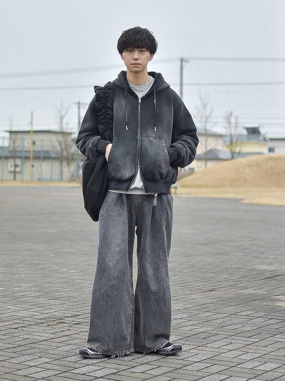 ブラック系のパーカー、グレー系のスウェット、ブラック系のデニムパンツを着用したメンズの春コーディネートの2枚目の写真
