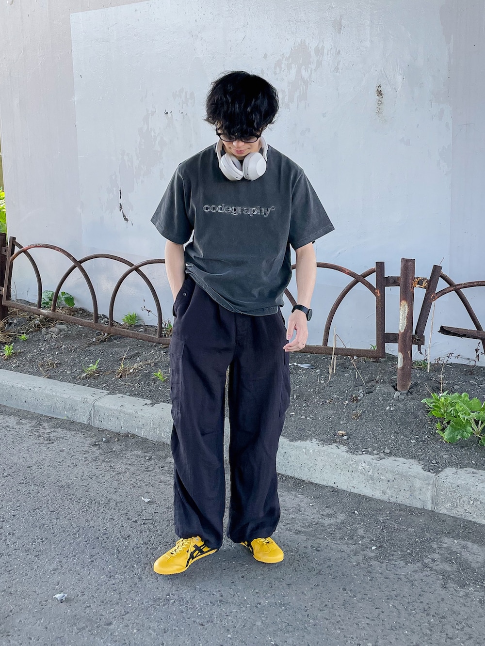 ブラック系のTシャツ/カットソー、ブラック系のカーゴパンツ、イエロー系のスニーカーを着用したメンズの春コーディネートの4枚目の写真