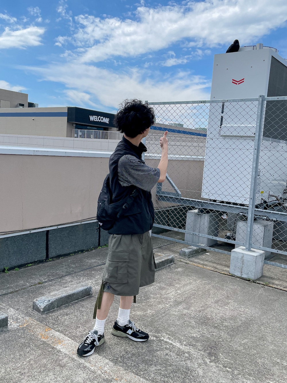 グリーン系のカーゴパンツ、グレー系のTシャツ/カットソー、ブラック系のショルダーバッグを着用したメンズの夏コーディネートの2枚目の写真