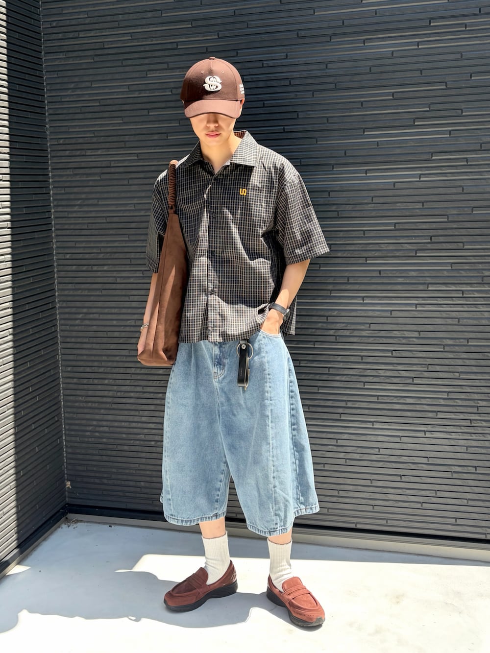 ブラック系のシャツ/ブラウス、ブルー系のデニムパンツ、ブラウン系のスニーカーを着用したメンズの夏コーディネートの2枚目の写真