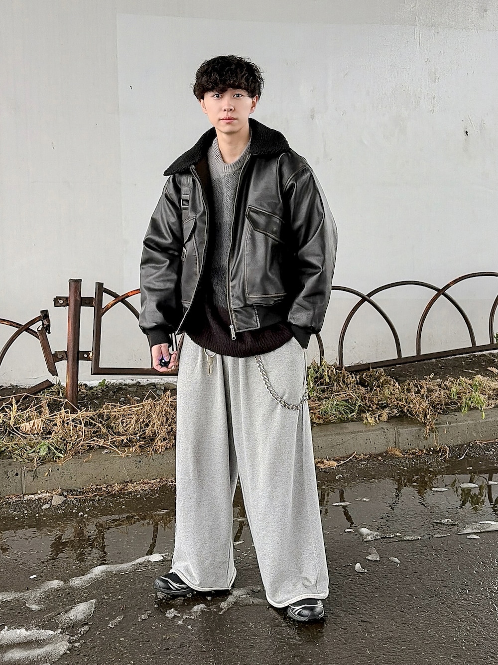 ブラック系のニット/セーター、ブラック系のブルゾン、グレー系のスウェットパンツを着用したメンズの冬コーディネートの4枚目の写真