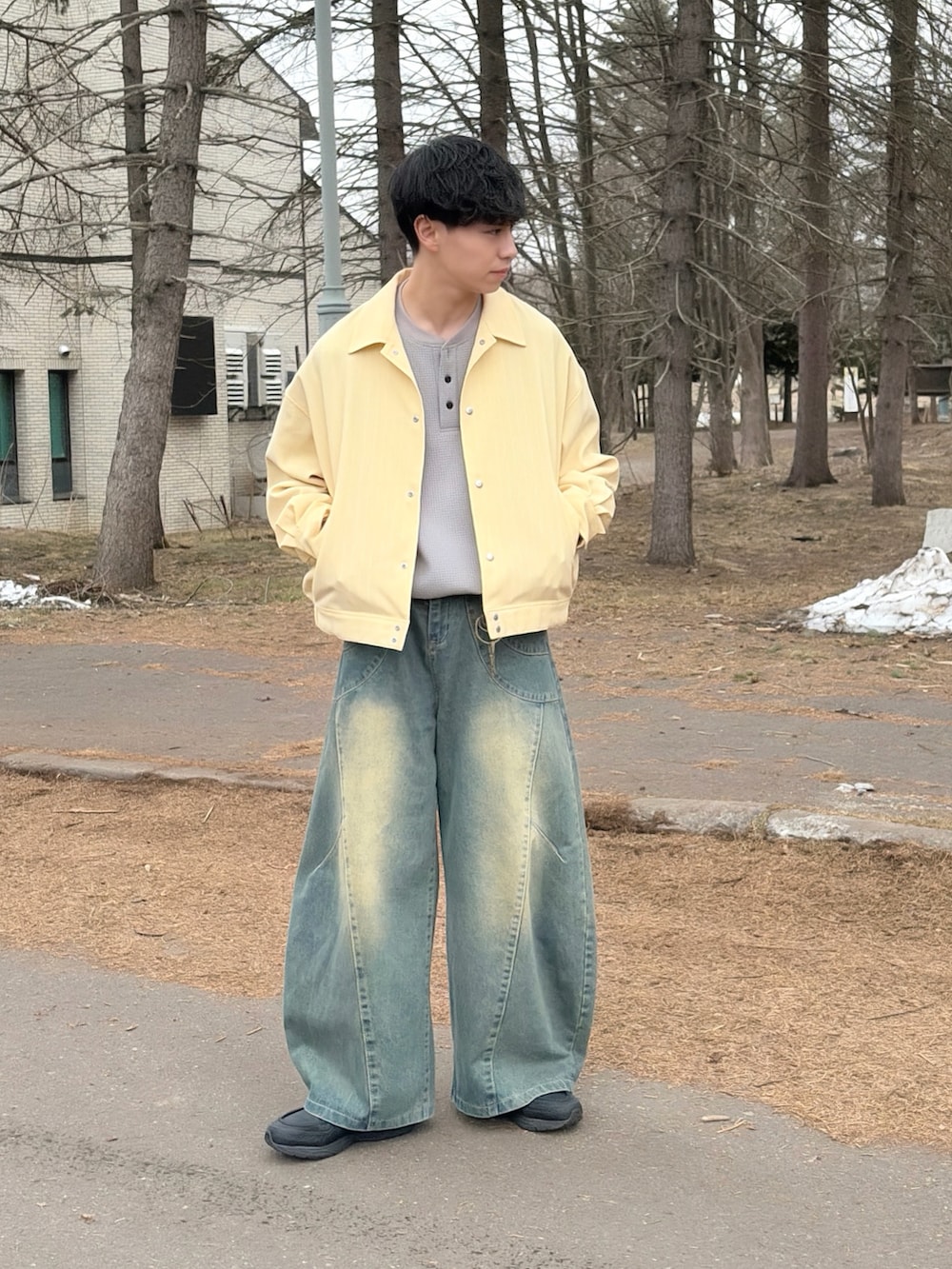 イエロー系のブルゾン、グレー系のTシャツ/カットソー、ブルー系のデニムパンツを着用したメンズの春コーディネートの2枚目の写真