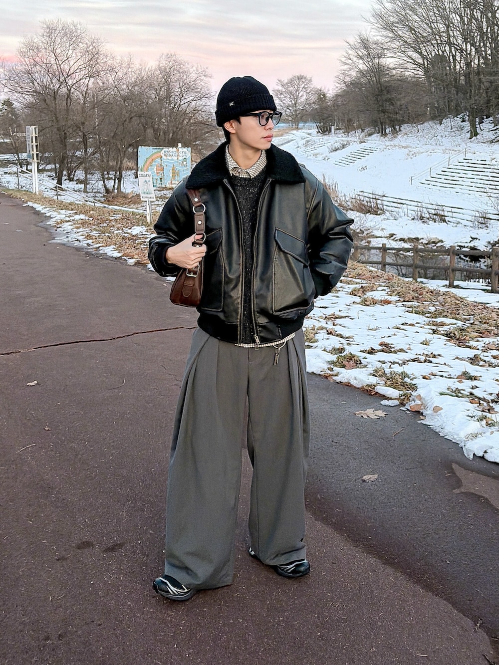 ブラック系のニット/セーター、ブラック系のブルゾン、グレー系のスラックスを着用したメンズの冬コーディネートの4枚目の写真