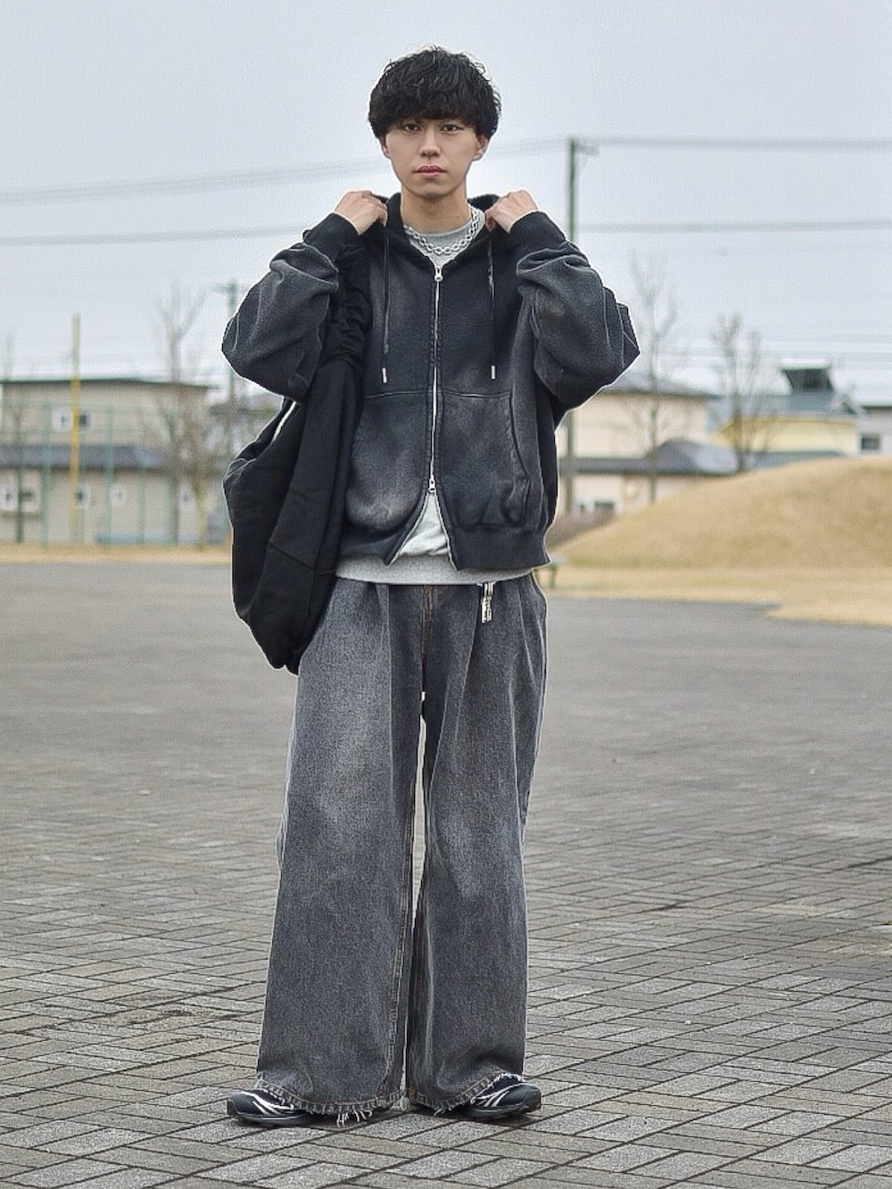 ブラック系のパーカー、グレー系のスウェット、ブラック系のデニムパンツを着用したメンズの春コーディネートの3枚目の写真