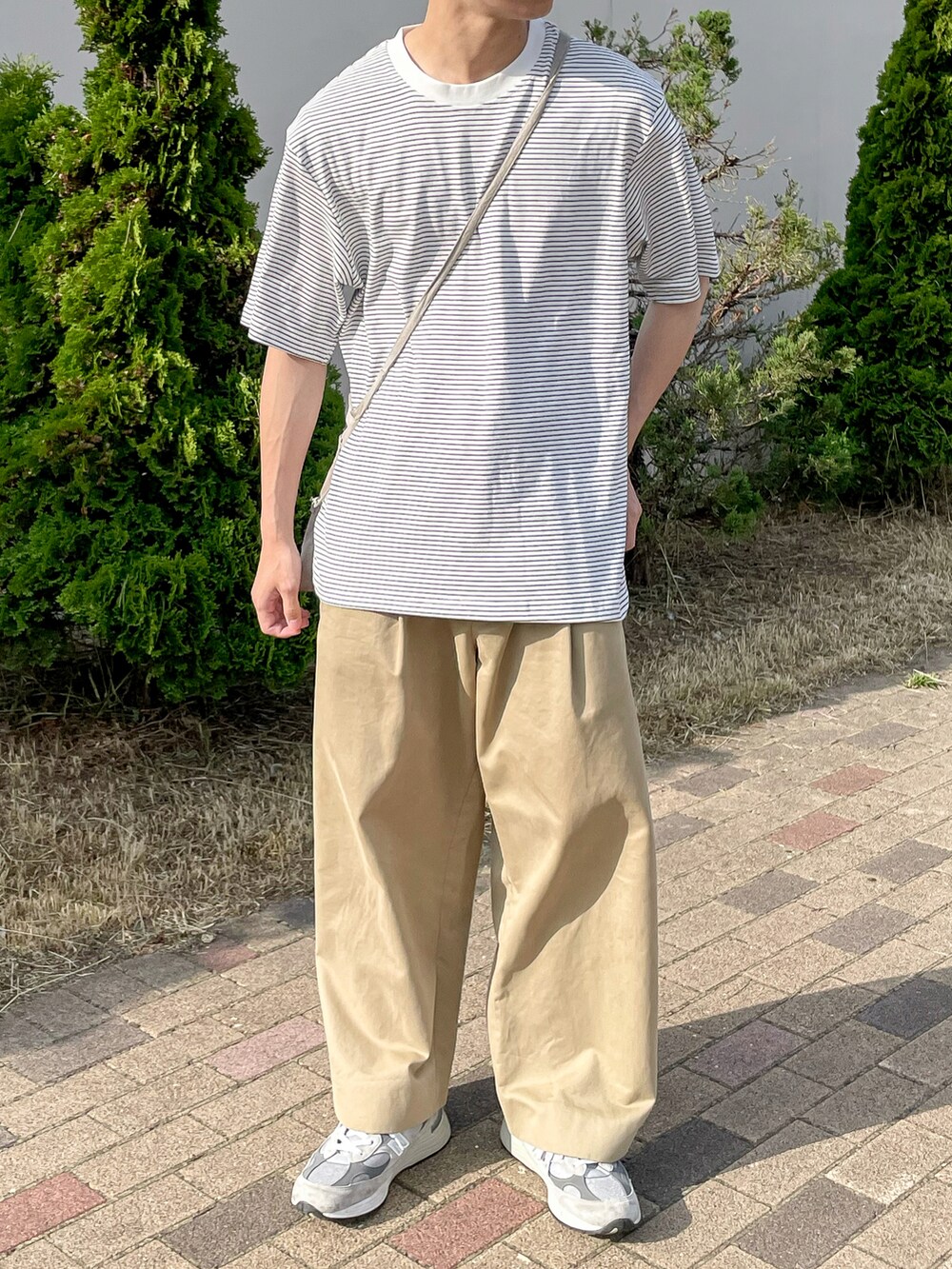 ホワイト系のトップス、ベージュ系のその他パンツ、グレー系のスニーカーを着用したメンズの夏コーディネートの3枚目の写真