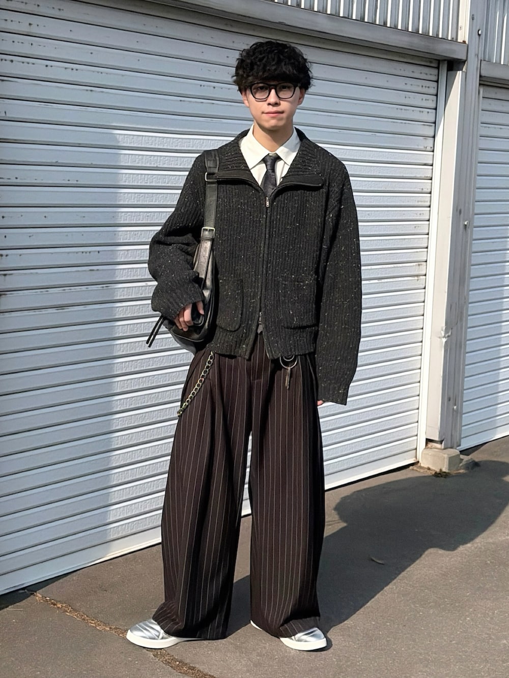 ブラック系のニット/セーター、ホワイト系のシャツ/ブラウス、ブラック系のネクタイを着用したメンズの冬コーディネートの2枚目の写真