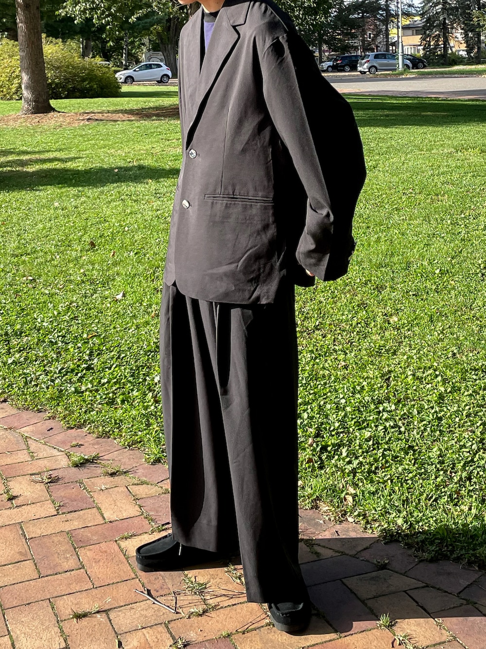 ブラック系のテーラードジャケット、ブラック系のその他パンツ、ブラック系のモカシン/デッキシューズを着用したメンズの秋コーディネートの3枚目の写真