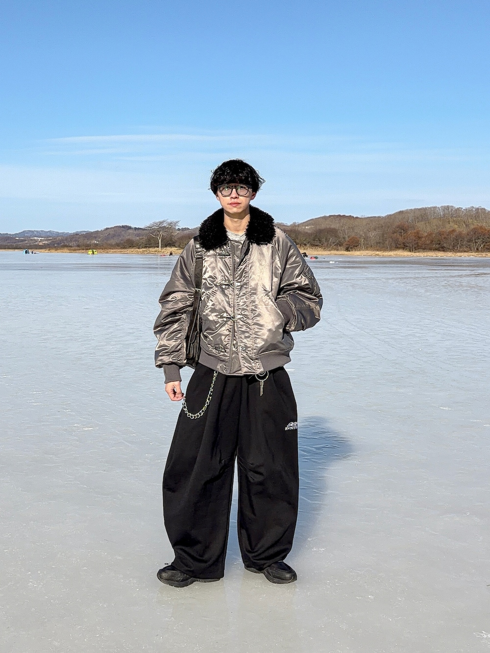 グレー系のスウェット、ブラック系のスウェットパンツ、グレー系のブルゾンを着用したメンズの冬コーディネートの3枚目の写真