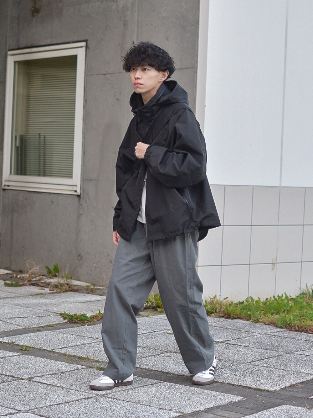 グレー系のデニムパンツ、ブラック系のブルゾン、ベージュ系のスウェットを着用したメンズの秋コーディネートの5枚目の写真
