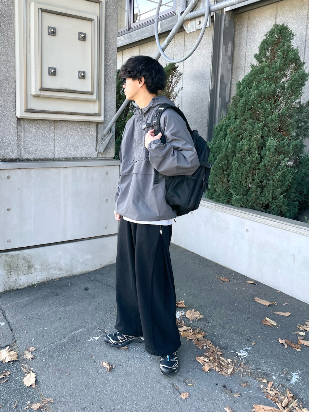 グレー系のナイロンジャケット、グレー系のスウェット、ブラック系のスウェットパンツを着用したメンズの秋コーディネートの4枚目の写真