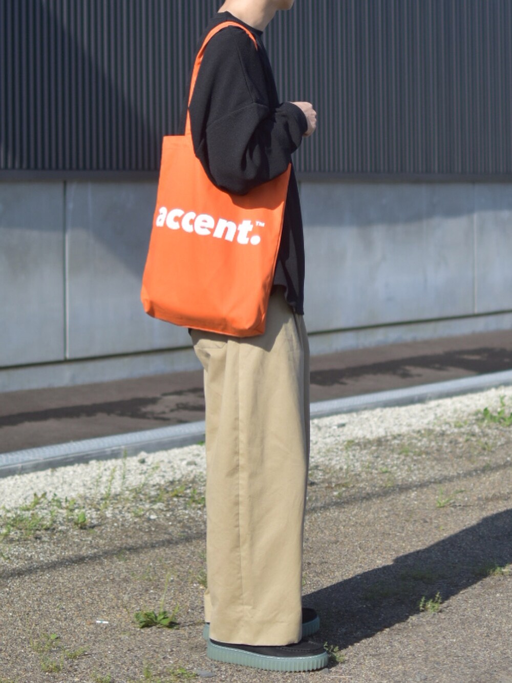 ブラック系のTシャツ/カットソー、ベージュ系のその他パンツ、ブラック系のモカシン/デッキシューズを着用したメンズの秋コーディネートの4枚目の写真