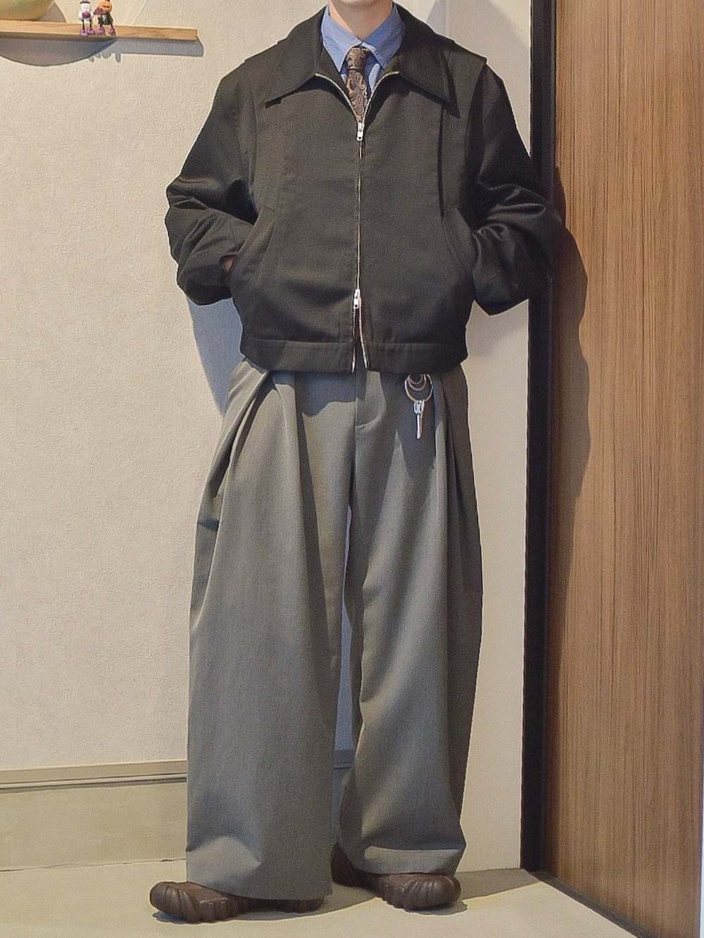 ブラック系のブルゾン、ブルー系のシャツ/ブラウス、グレー系のスラックスを着用したメンズの秋コーディネートの2枚目の写真