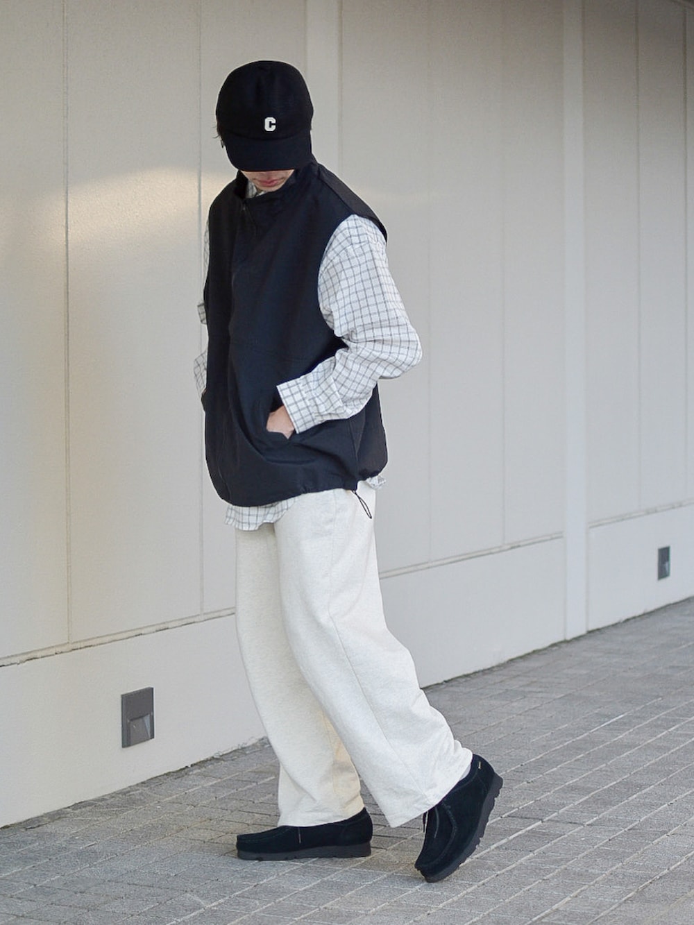 ブラック系のベスト、ホワイト系のシャツ/ブラウス、ホワイト系のスウェットパンツを着用したメンズの冬コーディネートの2枚目の写真