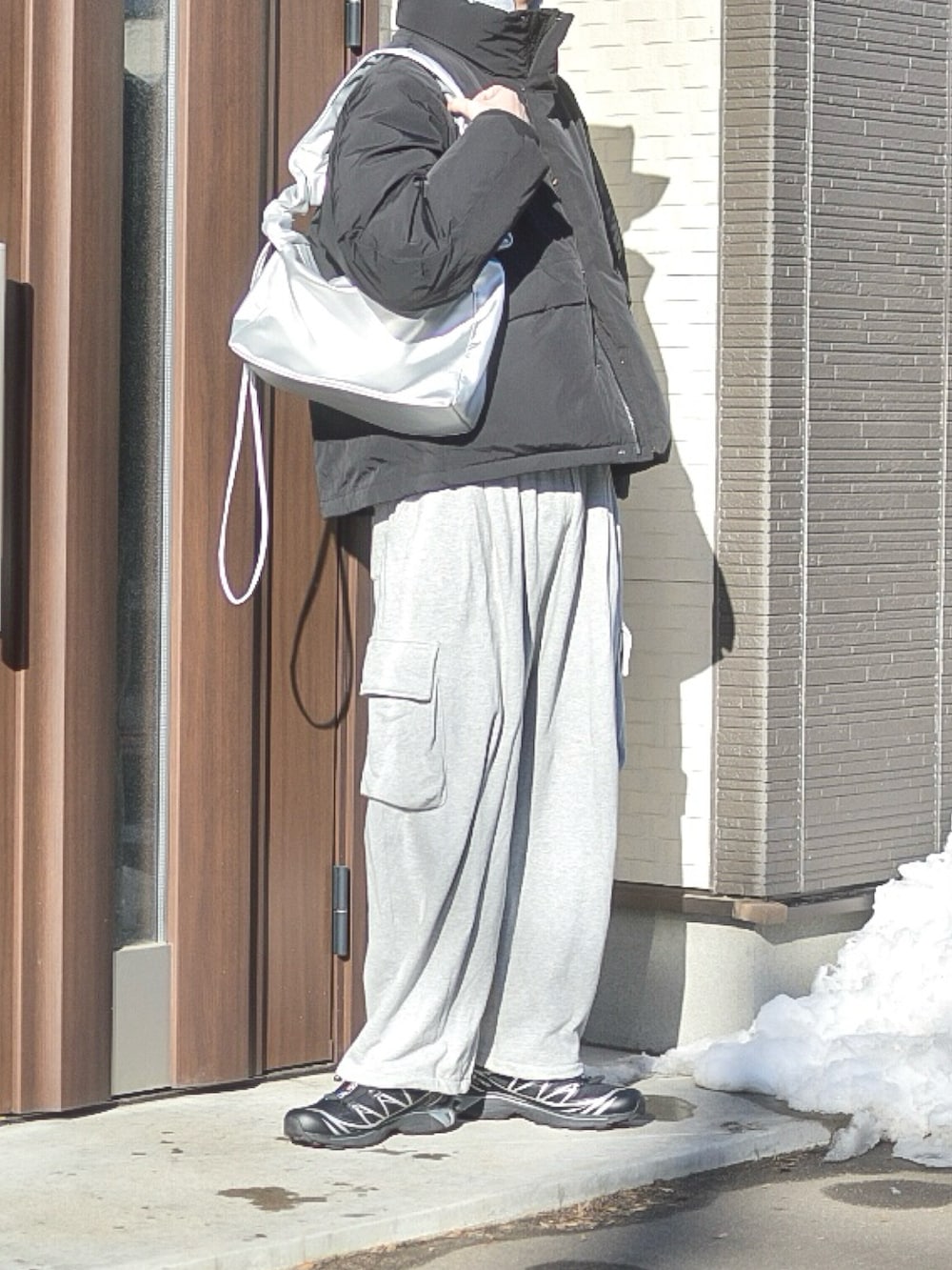 ブラック系のダウンジャケット/コート、グレー系のスウェットパンツ、ブラック系のスニーカーを着用したメンズの冬コーディネートの2枚目の写真