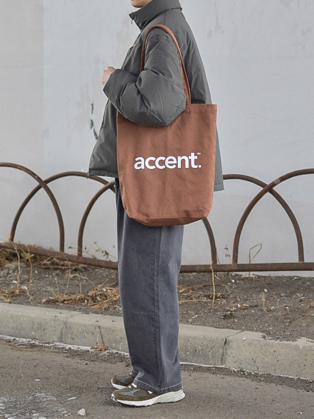 グレー系のジャケット/アウター、グレー系のデニムパンツ、ブラウン系のトートバッグを着用したメンズの冬コーディネートの4枚目の写真