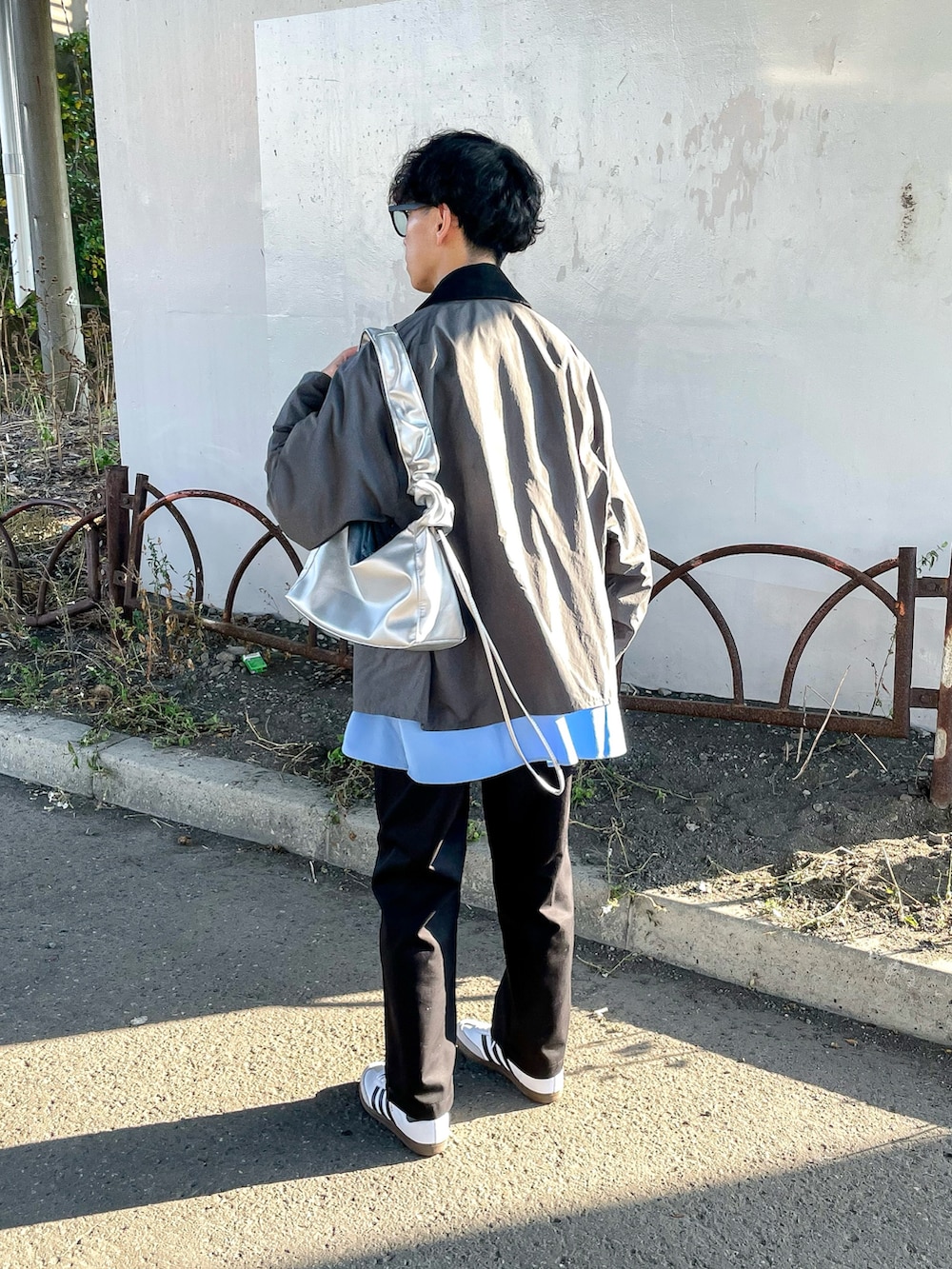 グレー系のナイロンジャケット、ブラック系のチノパンツ、ブルー系のシャツ/ブラウスを着用したメンズの秋コーディネートの4枚目の写真