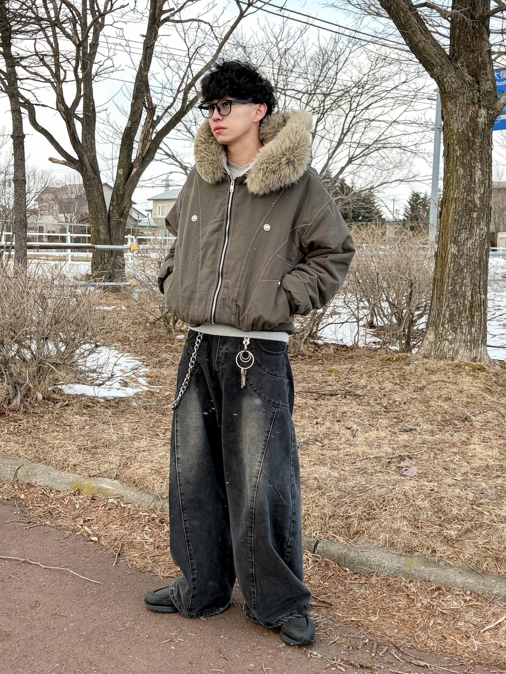 ブラウン系のブルゾン、ブラック系のデニムパンツ、グレー系のスウェットを着用したメンズの冬コーディネートの2枚目の写真