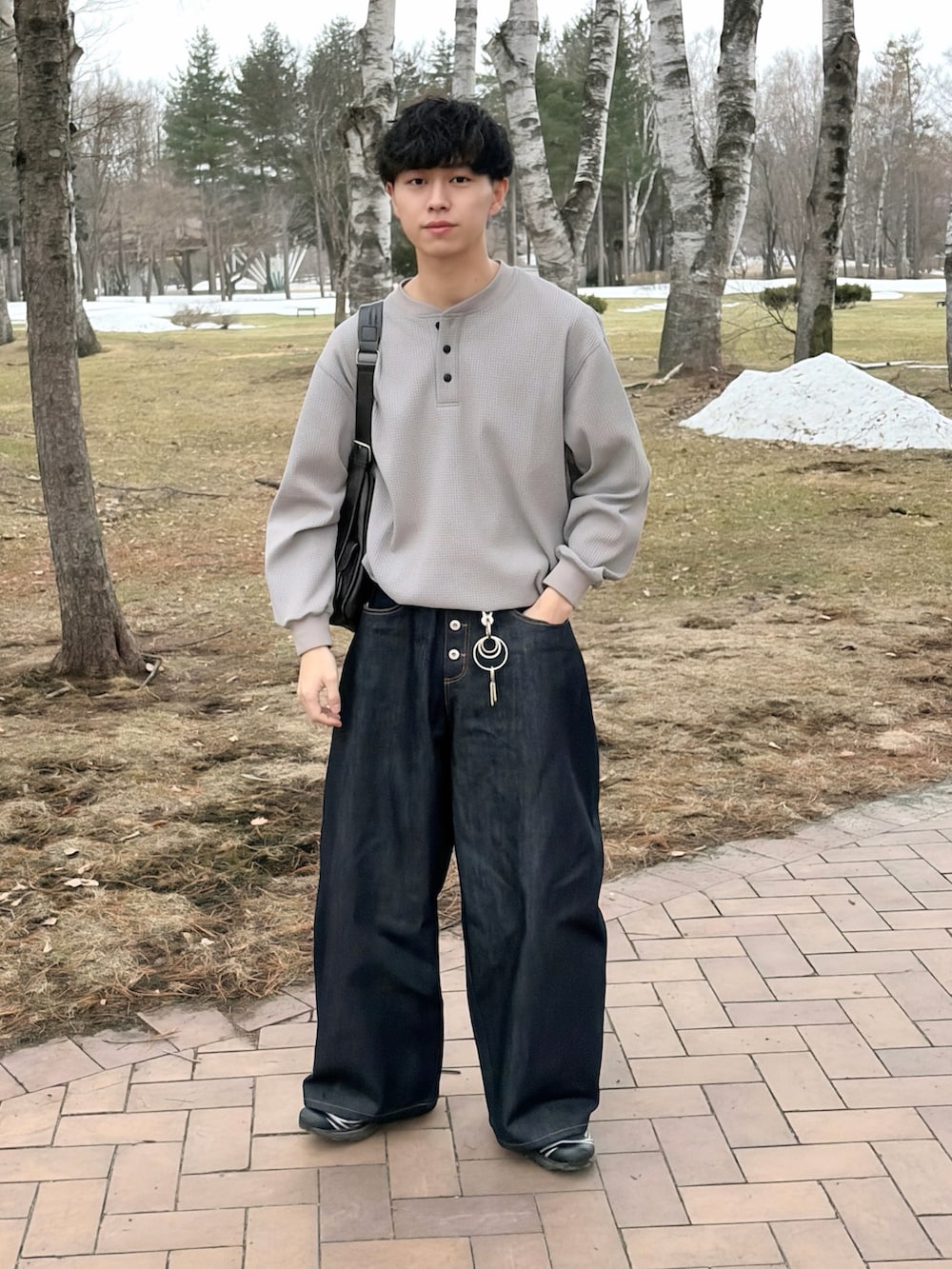 グレー系のTシャツ/カットソー、ブルー系のデニムパンツ、ブラック系のショルダーバッグを着用したメンズの春コーディネートの2枚目の写真