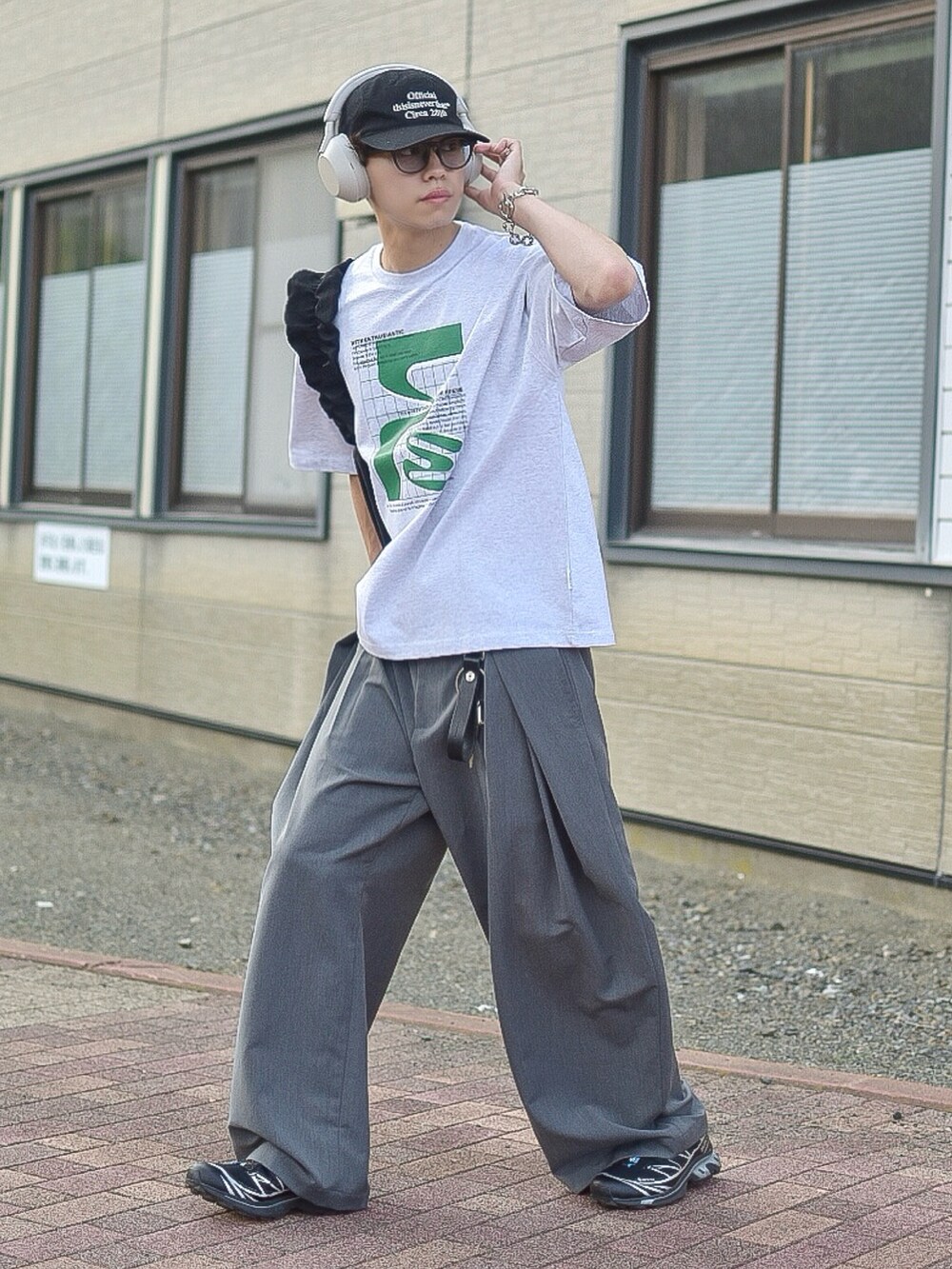 グレー系のTシャツ/カットソー、グレー系のスラックス、ブラック系のスニーカーを着用したメンズの夏コーディネートの2枚目の写真